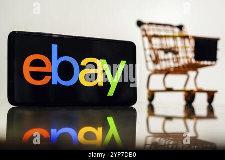 Dans cette illustration photo, le logo eBay vu affiché sur un smartphone avec un panier Banque D'Images