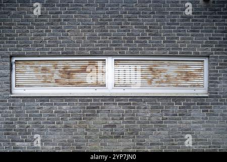 Grilles de ventilation rouillées dans un mur de briques Banque D'Images
