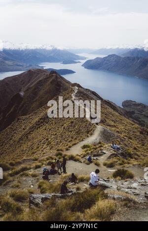 Les gens sur un chemin de montagne avec une vue large sur un lac, Roys Peak, Wanaka, Nouvelle-Zélande, Océanie Banque D'Images