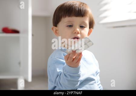 Petit garçon avec des pilules à la maison. Enfant en danger Banque D'Images