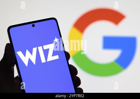 Dans cette illustration photo, le logo Wiz vu affiché sur l'écran d'un smartphone et le logo Google en arrière-plan Banque D'Images