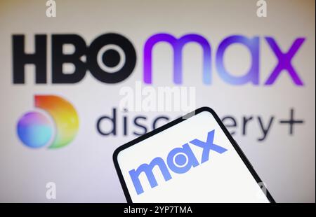 Dans cette illustration photo, le logo Max est affiché sur un smartphone et le logo HBO Max et Discovery sur le fond Banque D'Images