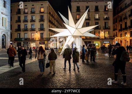 28 novembre 2024, Barcelone, Espagne. Les gens passent devant une étoile géante illuminant la place de la mairie dans le centre de Barcelone dans le cadre des décorations de Noël 2024. Crédit image : Jordi Boixareu/Alamy Live News Banque D'Images