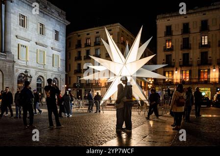 28 novembre 2024, Barcelone, Espagne. Un couple s'embrasse devant une étoile géante qui illumine la place de la mairie dans le centre de Barcelone dans le cadre des décorations de Noël 2024. Crédit image : Jordi Boixareu/Alamy Live News Banque D'Images