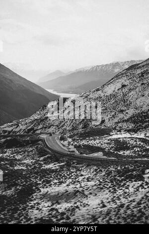 Paysage montagneux enneigé avec route sinueuse dans une sombre image en noir et blanc, Queenstown, Nouvelle-Zélande, Océanie Banque D'Images