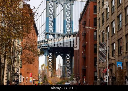 Une vue pittoresque sur le pont de Manhattan encadré par les bâtiments emblématiques en briques rouges de DUMBO à Brooklyn, New York. L'Empire State Building est perfe Banque D'Images