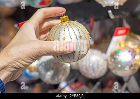 Tenez dans la main boule décorative du nouvel an pour décorer l'arbre de Noël et l'intérieur. préparatifs des fêtes Banque D'Images