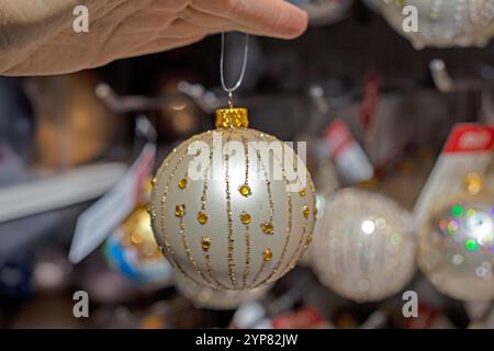 Tenez dans la main boule décorative du nouvel an pour décorer l'arbre de Noël et l'intérieur. préparatifs des fêtes Banque D'Images