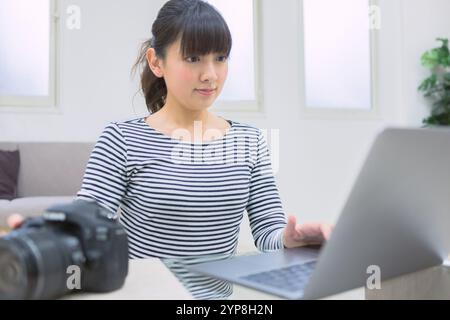 Femme vérifiant les photos prises Banque D'Images