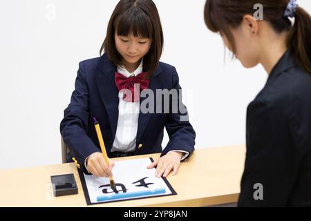 Lycéenne faisant de la calligraphie Banque D'Images