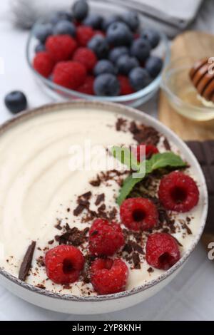 Savoureux porridge de semoule cuit avec des baies servies sur table, gros plan Banque D'Images