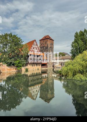 Vieille ville historique avec vue sur le bâtiment Weinstadel, château d'eau, pont Henkerbrücke et tour Henkerturm à Nuremberg, Allemagne. Banque D'Images