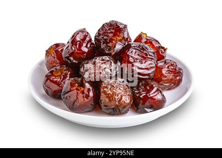 Pile de fruits de jujube chinois dénoyautés sucrés conservés dans du sirop dans un plat en céramique blanche isolé sur fond blanc avec chemin de découpage. Banque D'Images