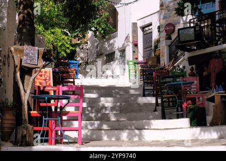 Naxos : Restaurant, chaises colorées et marches jusqu'à Eglise de la Vierge de Filoti à Filoti, Naxos, île des Cyclades, Grèce Banque D'Images