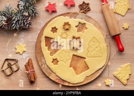 La pâte à biscuits de Noël est préparée avec des découpeurs et des décorations festives, créant une atmosphère chaleureuse de vacances Banque D'Images