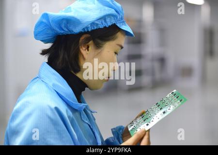 FUYANG, CHINE - 29 NOVEMBRE 2024 - Un membre du personnel produit et inspecte un contrôleur à l'atelier de production SMT d'Anhui Shixin Electronic Techno Banque D'Images