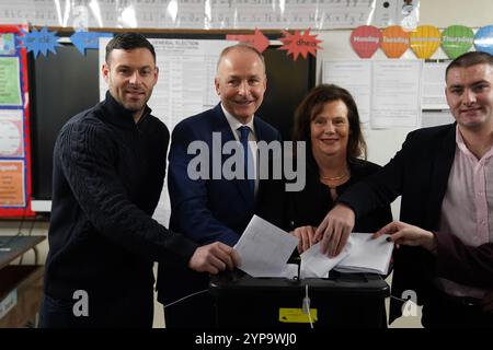 Tanaiste et le leader du Fianna Fail Micheal Martin, accompagné de sa famille, votent à la St Anthony's Boys' School, Beechwood Park, Ballinlough, Cork, alors que les électeurs se rendent aux urnes pour les élections générales de 2024 en Irlande. Date de la photo : vendredi 29 novembre 2024. Banque D'Images