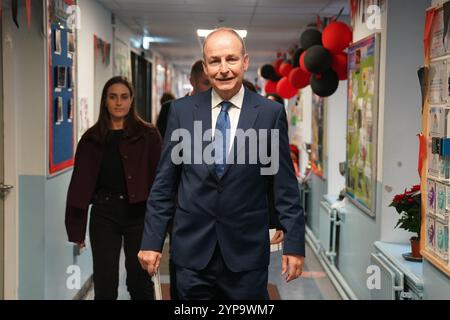 Tanaiste et le leader du Fianna Fail Micheal Martin, accompagné de sa famille, votent à la St Anthony's Boys' School, Beechwood Park, Ballinlough, Cork, alors que les électeurs se rendent aux urnes pour les élections générales de 2024 en Irlande. Date de la photo : vendredi 29 novembre 2024. Banque D'Images