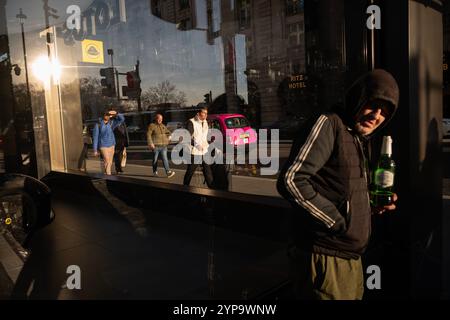 Homme sans-abri tenant une bouteille de Stella Artois le long de Piccadilly, la rue la plus riche de Londres où riches et pauvres se côtoient, Angleterre, Royaume-Uni Banque D'Images