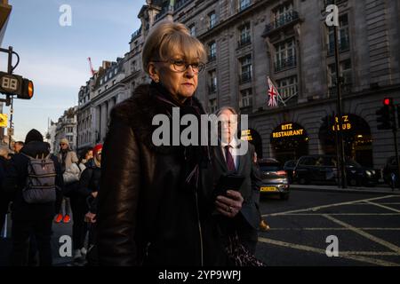 Une dame descend Piccadilly de l'autre côté de l'hôtel et restaurant RITZ, au cœur de Mayfair, le quartier le plus riche de Londres, Angleterre, Royaume-Uni Banque D'Images