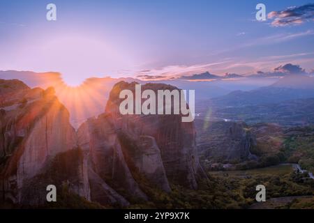 Grèce septentrionale. Météores roche dans les montagnes de Thessalie. Les derniers rayons de coucher de soleil sur la vallée verdoyante de Kalambaka Banque D'Images