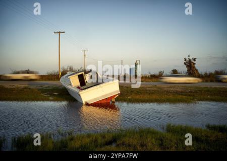 Un bateau de pêche abandonné se trouve partiellement immergé dans l'eau. Banque D'Images