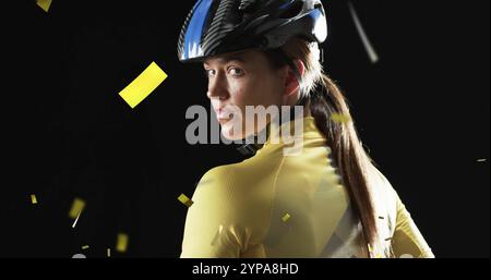 Image de confettis tombant sur une cycliste féminine caucasienne sur fond noir Banque D'Images