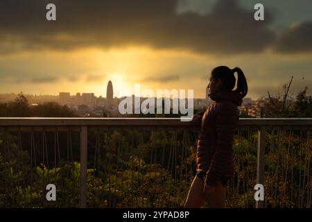 Beau lever de soleil sur la ville et la femme qui la regarde. Banque D'Images