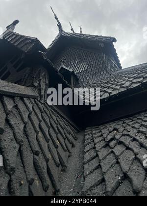 Vue d'en bas du toit en bois de l'église norvégienne viking de Borgund du XIIe siècle, avec un artisanat médiéval sous un ciel nuageux. Medi Banque D'Images