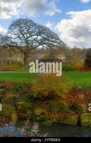 Une scène automnale avec un jardin de rocaille tranquille, belvédère en bois, et un ruisseau peu profond, RHS Garden, Harlow Carr, Harrogate, Yorkshire. Banque D'Images