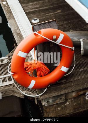 Bouée de sauvetage dans la marina. Anneau de sécurité de vie d'une bouée rouge sur un poteau sur la rive de la rivière Banque D'Images