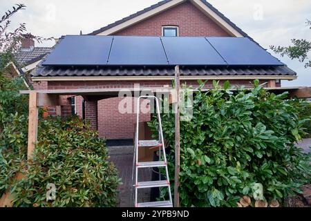 Très petit panneau solaire résidentiel installé sur un abri de voiture d'une maison néerlandaise, montrant qui est le succès de la politique néerlandaise en matière d'énergie verte. Banque D'Images