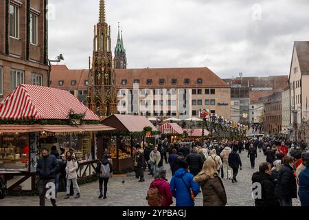 Eröffnungstag des Nürnberger Christkindlesmarkts 2024, 29.11.2024 Besucher flanieren über den Nürnberger Christkindlesmarkt 2024, entlang der festlich geschmückten Verkaufsstände mit rot-Weiß gestreiften Dächern. IM Zentrum steht der Schöne Brunnen, der das weihnachtliche Marktgeschehen ergänzt, Nürnberg Bayern Deutschland *** jour d'ouverture du Nuremberg Christkindlesmarkt 2024, 29 11 2024 visiteurs se promènent dans le Nuremberg Christkindlesmarkt 2024, le long des étals décorés de façon festive avec des toits rayés rouges et blancs dans le centre est la belle fontaine, qui complète le Noël Banque D'Images