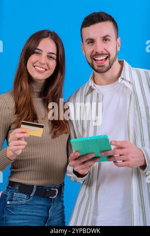 Couple souriant avec carte de crédit et tablette. Vertical Banque D'Images