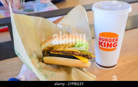 Hanovre, Allemagne. 29 novembre 2024. ILLUSTRATION - Un homme tient un hamburger à base de plantes Big King dans un restaurant de chaîne de restauration rapide Burger King. Crédit : Julian Stratenschulte/dpa/Alamy Live News Banque D'Images