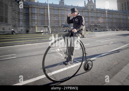 Londres, Royaume-Uni. 29 novembre 2024. Neil Laughton du Penny Farthing Club, fondé en 2013, court à Westminster sur son vélo moderne de style victorien. Crédit : Guy Corbishley/Alamy Live News Banque D'Images