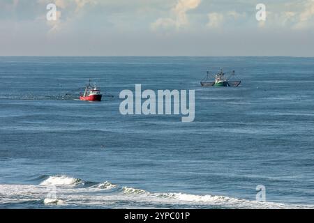 Deux coupeurs, l'un avec des filets de traînée levés sur l'eau bleue de la mer du Nord près de la plage Banque D'Images