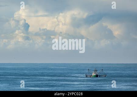 Un couteau avec filets de traînée levés sur l'eau bleue de la mer du Nord avec des nuages ensoleillés Banque D'Images