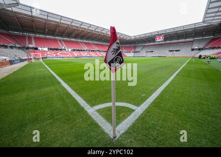 Symbolbild für den SC Freiburg, Eckfahne mit Vereinslogo im Fokus, im Hintergrund das Stadion mit roten Sitzreihen und dem Schriftzug ãSC FreiburgÒ, grüner, gepflegter Rasen mit klaren weißen Spielfeldmarkierungen, leere Tribünen und ruhige Atmosphäre vor Spielbeginn, repräsentiert Heimat, Professionalität und die Verbindung zwischen Verein und Stadion für Vereinsidentität Fußballkultur dans le fond le stade avec des rangées rouges de sièges et le lettrage ÒSC FreiburgÓ, vert, bien Banque D'Images