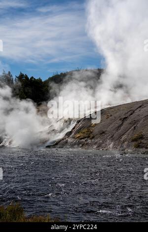 Une source de geyser active avec une décharge intermittente d'eau éjectée turbulemment et accompagnée de vapeur, parc national de Yellowstone, États-Unis Banque D'Images