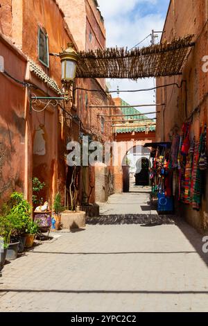 Sacs et vêtements en vente dans la ruelle étroite de la vieille ville. Marrakech, Maroc, Afrique Banque D'Images