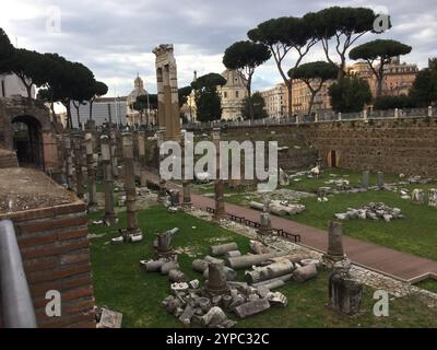 Les ruines présentent les vestiges d'un site historique, avec des colonnes tombées et des pierres brisées. Une végétation luxuriante entoure la zone, créant un contraste avec le Banque D'Images