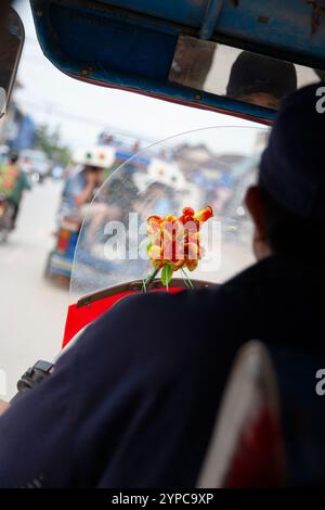 Luang Prabang, Laos - 9 avril 2011 : homme conduisant un tuk tuk dans la rue près de Luang Prabang, Laos Banque D'Images