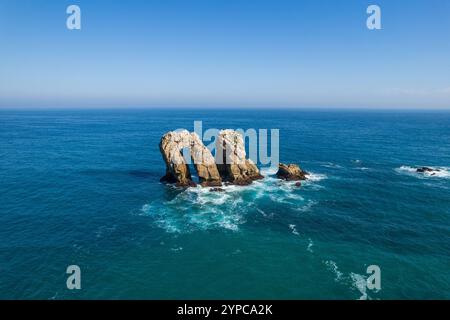 Urro del Manzano au coucher du soleil, Liencres, Espagne. Formation rocheuse pont en arc naturel à Arnia Costa Quebrada.. Paysage de Cantabrie, mer et belle couleur Banque D'Images