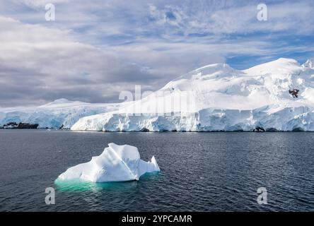 Un paysage antarctique tranquille, près du passage Graham le long de Charlotte Bay, mettant en évidence des reflets frappants, des montagnes escarpées et des icebergs impressionnants. Banque D'Images