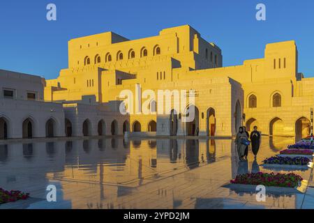 Femme locale en tenue traditionnelle se promener sur la place principale de l'Opéra Royal dans la lumière du soir, Muscat, péninsule arabique, Sultanat d'Oman Banque D'Images