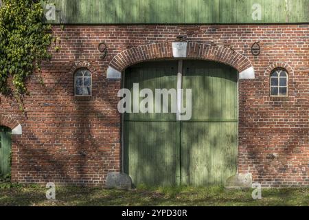 Un mur de briques avec une grande porte de grange verte et deux petites fenêtres, ferme, Muensterland, Rhénanie du Nord-Westphalie, Allemagne, Europe Banque D'Images