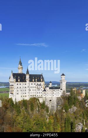 Le château de Neuschwanstein surplombe une forêt d'automne colorée sous un ciel clair, Schwangau, Ostallgaeu, Allgaeu, Souabe, haute Bavière, Bavière, Allemagne Banque D'Images