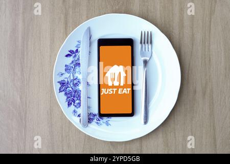 29 avril 2024, Brésil. Dans cette illustration photo, le logo Just-Eat est affiché sur un écran de smartphone à l'intérieur d'une assiette avec des couverts Banque D'Images