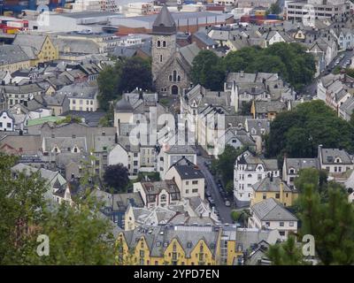 Vue sur une ville historique avec une église centrale et les bâtiments et arbres environnants, alesund, norvège Banque D'Images